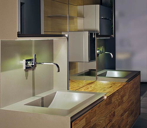 This bathroom is a design concept with olive wood; the Corian frame is wrapped-around,  mirrored overhead cabinets, LED lighting; drawer interior made in olive wood by Nagel, the premium brand